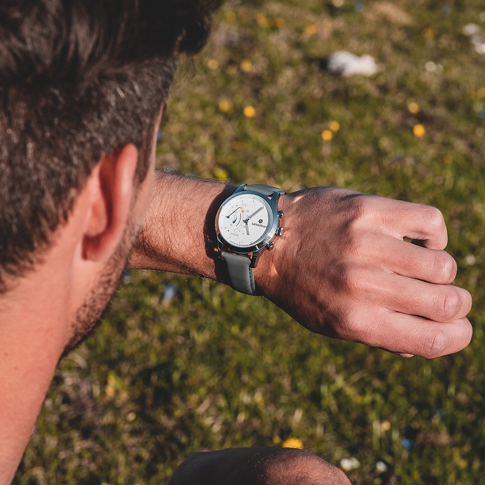 Seitenansicht eines Mannes mit Sanochron Armbanduhr im Freien.